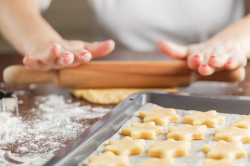 Woman baking ginger bread stars for Christmas. Natural Colors. R