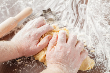 Hands kneading dough on board