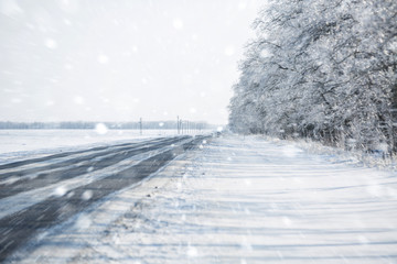 Obraz premium Winter road. Winter background. Drifts, snow, tire tread imprint. Copy space.