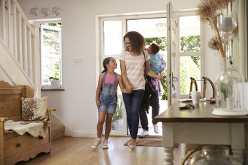 Family In Hallway Returning Home Together