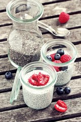 Overnight chia seeds pudding with fresh raspberries in glass jar. Healthy breakfast to go. Superfoods concept 