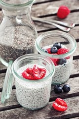Overnight chia seeds pudding with fresh raspberries in glass jar. Healthy breakfast to go. Superfoods concept 