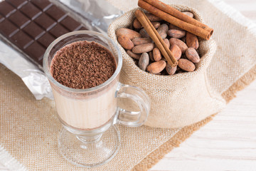 Fresh Made Chocolate Banana Smoothie on a wooden table with coffee and spices. Milkshake. Protein diet. Healthy food concept. Drink, cocoa beans, chocolate.