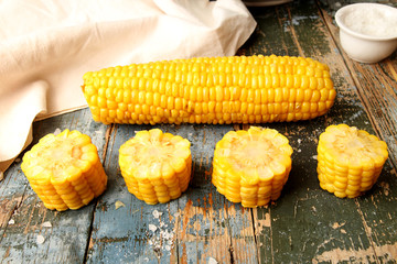 Boiled corn and chopped corn ear on rustic wooden table