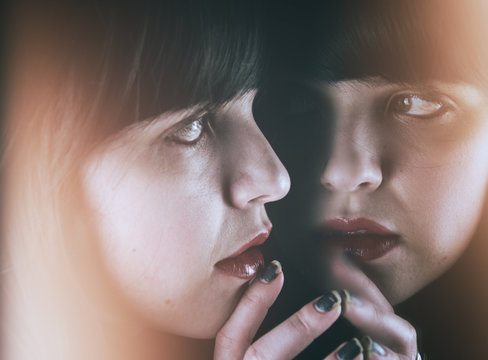 Retrato de una chica joven reflej&aacute;ndose frente a un espejo 