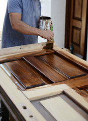 carpenter painting a wood door