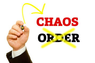 Hand writing CHAOS and ORDER word on a transparent wipe board.