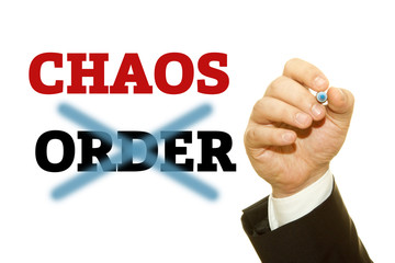 Hand writing CHAOS and ORDER word on a transparent wipe board.
