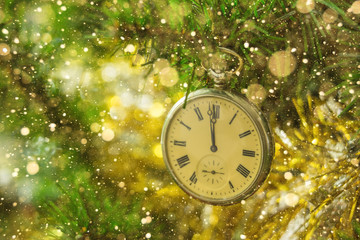 Vintage clock on a Christmas tree. Gold tinsel. Holiday decorations. close-up, glare, shine. Copy space.