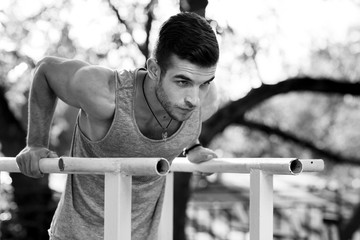 Black and white portrait of man pressed on parallel bars