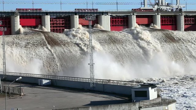 Spring flood water flowing on hydroelectric power station dam