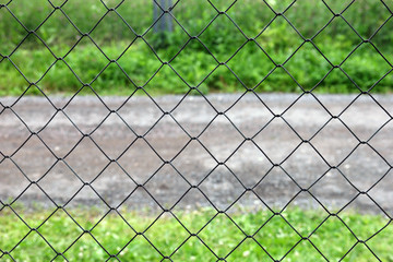 mesh netting galvanized on the background of the road and grass