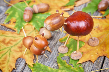 Small creatures made of chestnuts and acorns. Autumnal decoratio
