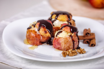 Baked apples on white plate, cinnamon sticks. Healthy eating. Close up.