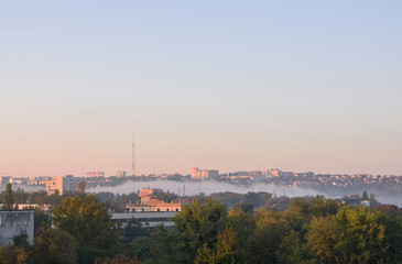 Fototapeta na wymiar Sunrise with fog over the Valea Morilor lake in Chisinau, Moldova. View on the national tv station antenna