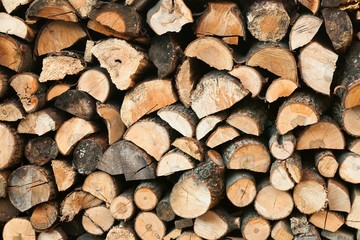 Stack of chopped firewoods prepared for winter. Wooden background