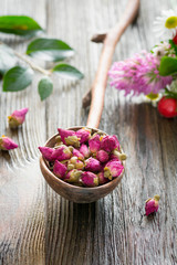 Rose tea buds in wooden spoon