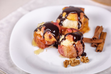 Baked apples on white plate, cinnamon sticks. Healthy eating. Close up.