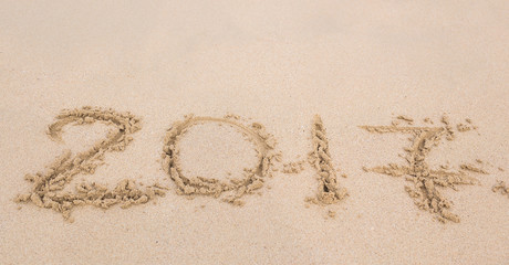 New Year 2017 is coming concept - inscription 2017 on a beach sand