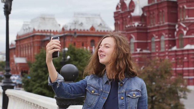 Smart phone selfie - young student tourist taking self portrait using smartphone camera. Kremlin, Moscow, Russia, 2016