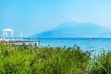 Landscape Lake Garda, Italy. Photo executed in blue and turquoise colors. Beautiful view of the lake and surrounding mountains.