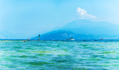 Landscape Lake Garda, Italy. Photo executed in blue and turquoise colors. Beautiful view of the lake and surrounding mountains.