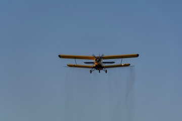 Crop duster spraying crops from the air in the morning light.