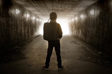 School child walking in a dark subway