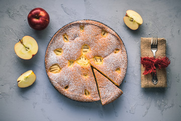 Angeschnittener Apfelkuchen auf grauem Untergrund