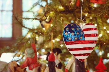 Heart shaped United States flag ornament hanging on Christmas tr