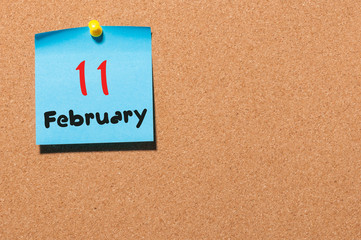 February 11th. Day 11 of month, calendar on cork notice board background. Winter concept. Empty space for text