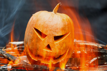 Obraz premium Burning Halloween pumpkin over a black background