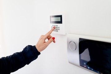 Young woman entering security code on keypad