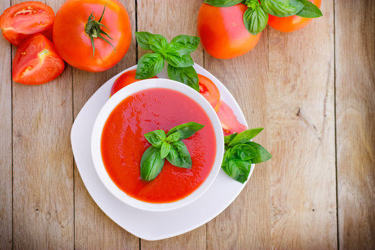 Freshly prepared homemade tomato soup in white bowl on table