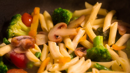 Primavera Pasta with mushrooms cooking in a pan
