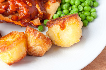 Crispy roast potatoes on the side of a dinner plate