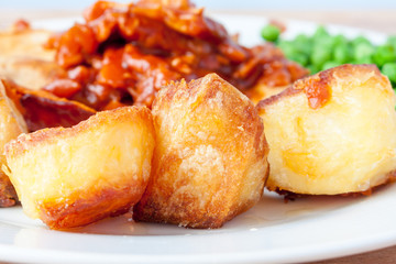 Crispy roast potatoes on the side of a dinner plate