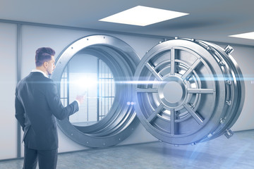 Man with smartphone standing near blue vault