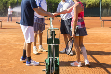 Mixed doubles tennis players shake hands before and after the te