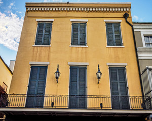 Yellow Building with Green Shutters, Lamps and Balcony
