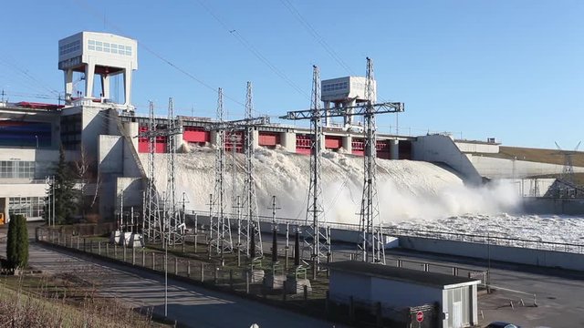 Spring flood water flowing on hydroelectric power station dam