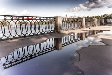 Reflection in pools on the embankment. St. Petersburg. Russia