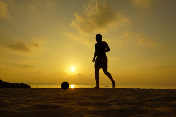 Fototapeta na wymiar Silhouettes of footballers on the sunset sky.