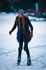 Young girl ice skating at rink in Trakai of Lithuania