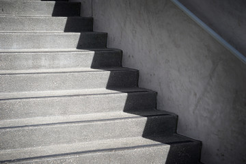 concrete stairs and handrail with shadows forming abstract design