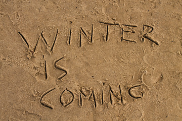Fototapeta premium Winter is coming sign on the wet sand beach