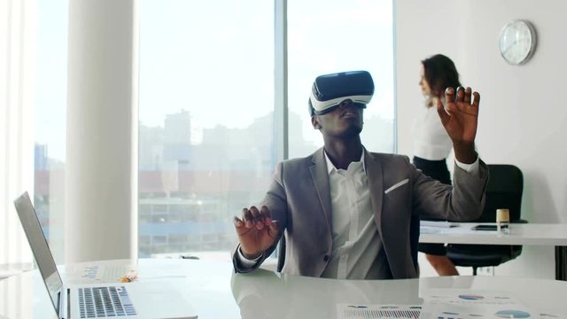 Young black man wearing virtual reality headsets in white future white office