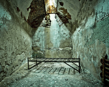 Cot in empty crumbling prison cell at Eastern State Penitentiary