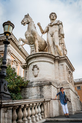 Fototapeta na wymiar Femme et statue des Dioscures devant le Capitole de Rome