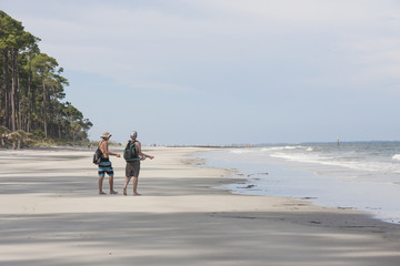Two male teens strolling on a beach